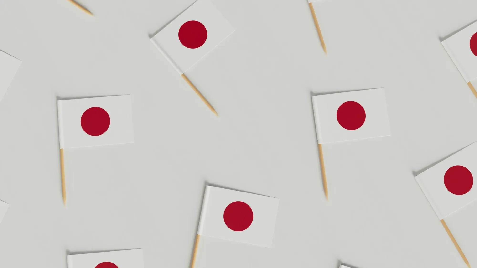 Japanese flag with Mount Fuji in background – national flag of Japan waving on a pole with inscriptions, set against the snow-capped peak of Mount Fuji.