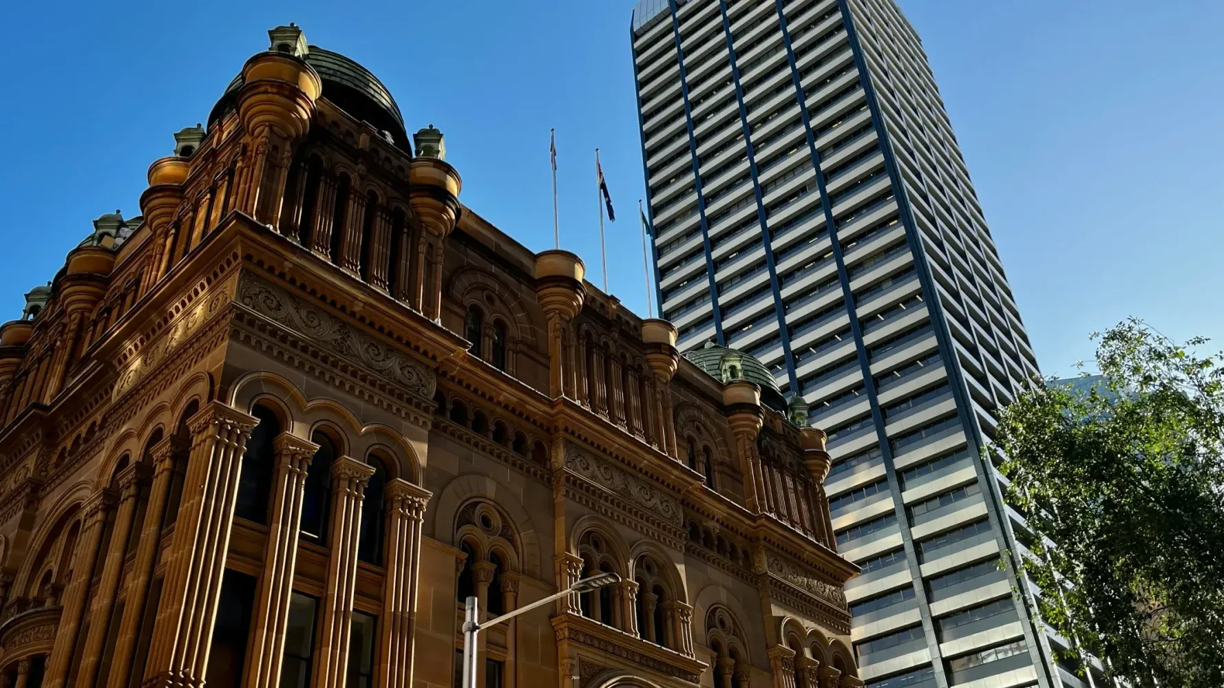 Historic building with columns next to a modern high-rise in a city center