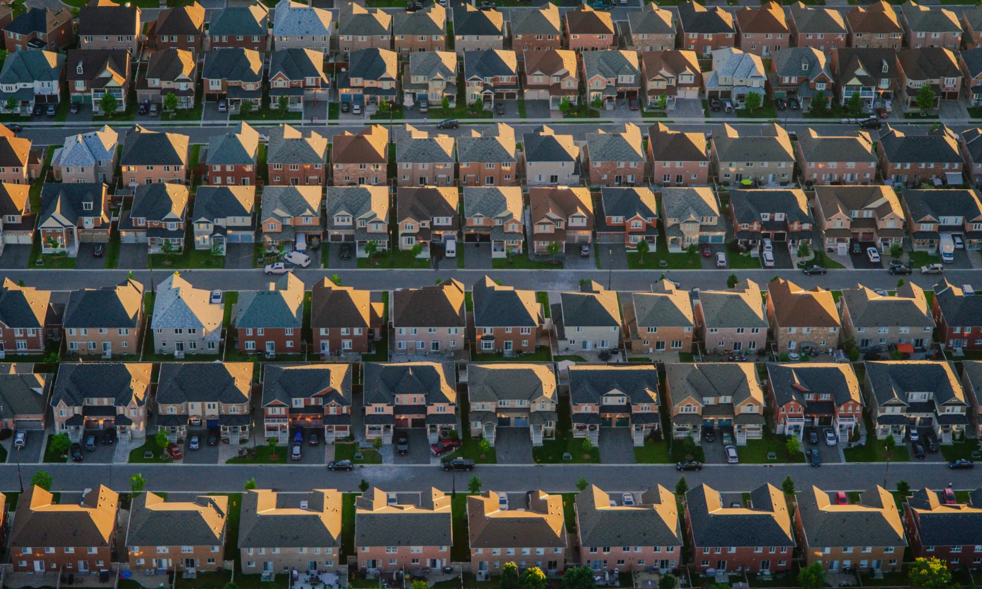 Aerial view of a suburban neighborhood with rows of similar-looking houses and streets