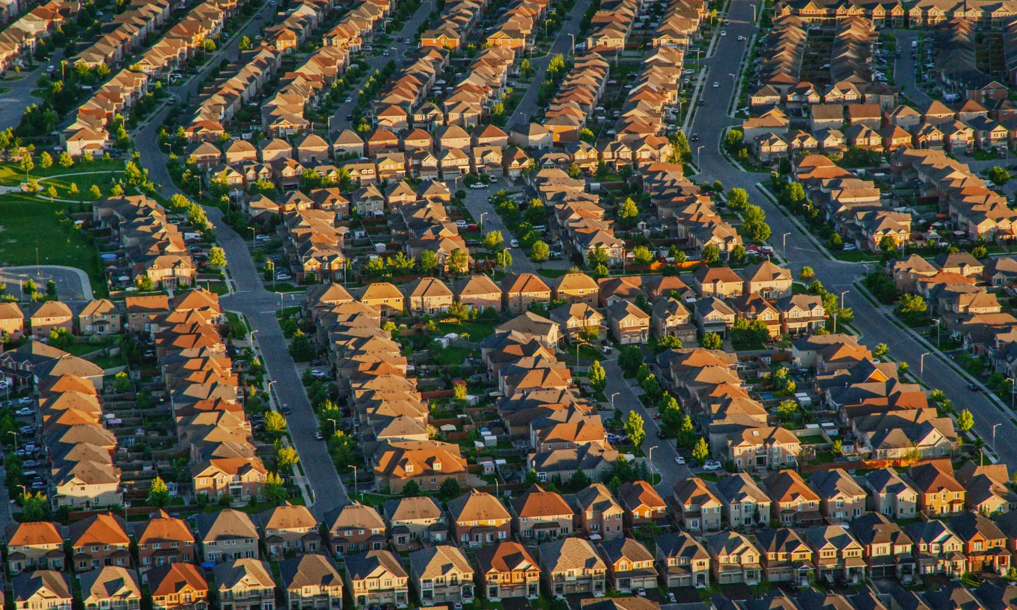 Aerial view of a suburban neighborhood with rows of houses and streets.