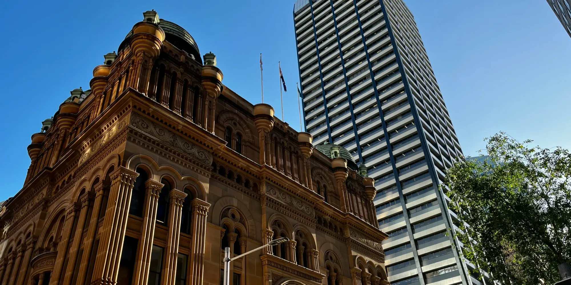 Historic building with columns next to a modern high-rise in a city center